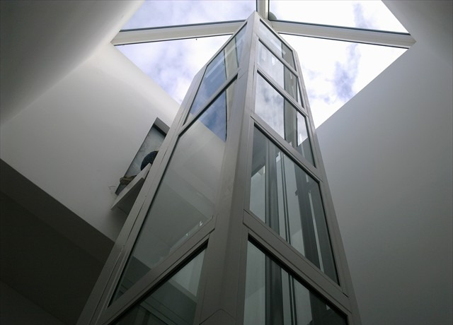Estrutura de elevador em vidro sob claraboia